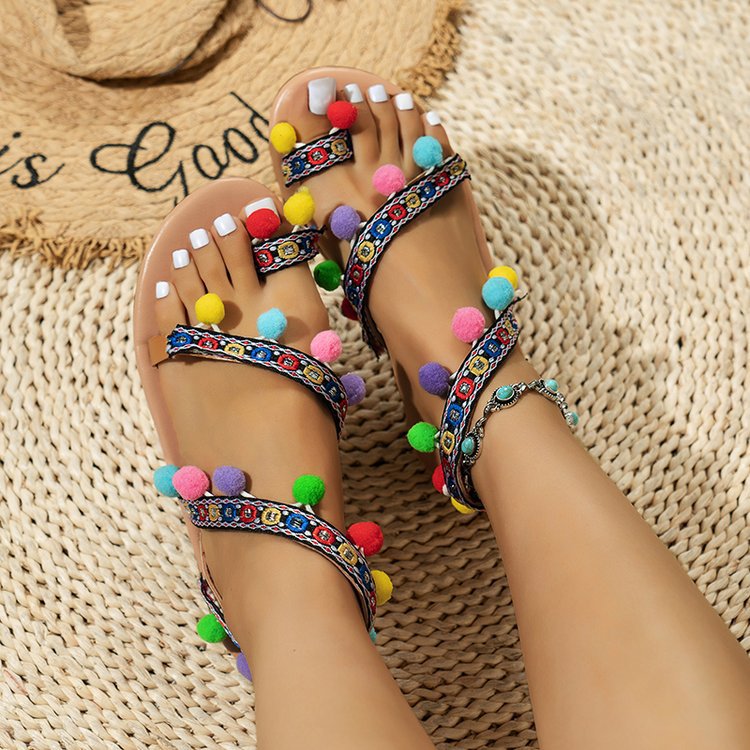 Sandalias planas bohemias con tiras cruzadas y pompones