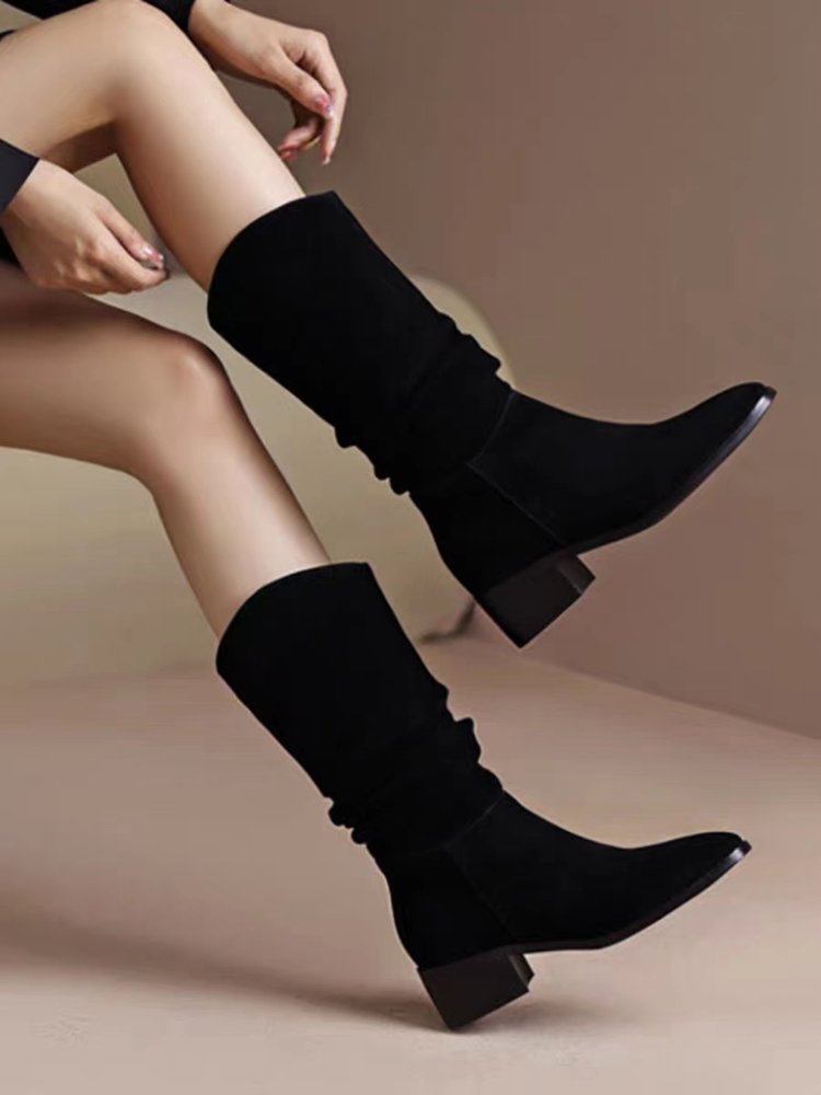 Elegantes botas negras altas hasta la rodilla de gamuza